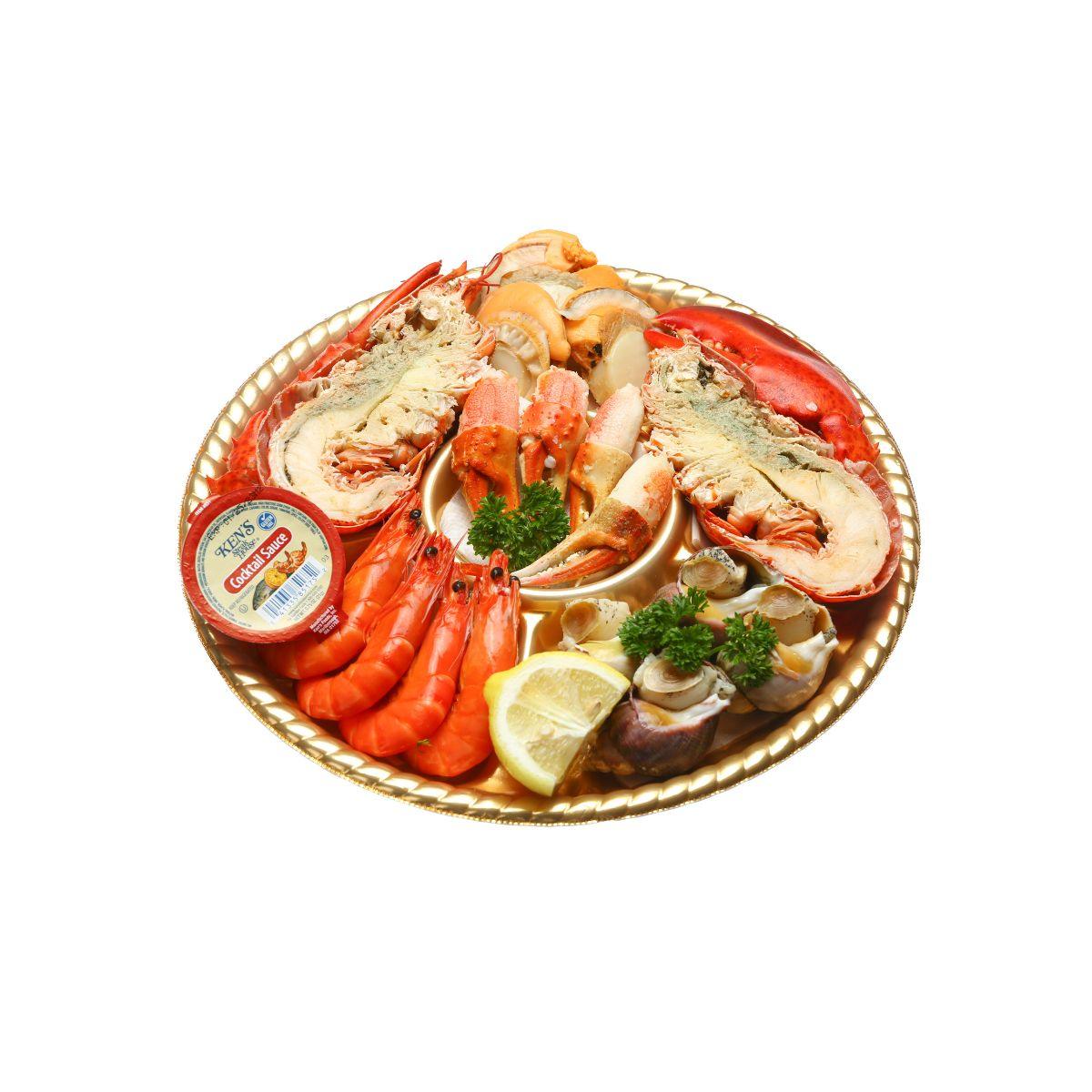 Seafood platter with shrimp, lobster, lemon slices, and mussels in a round tray