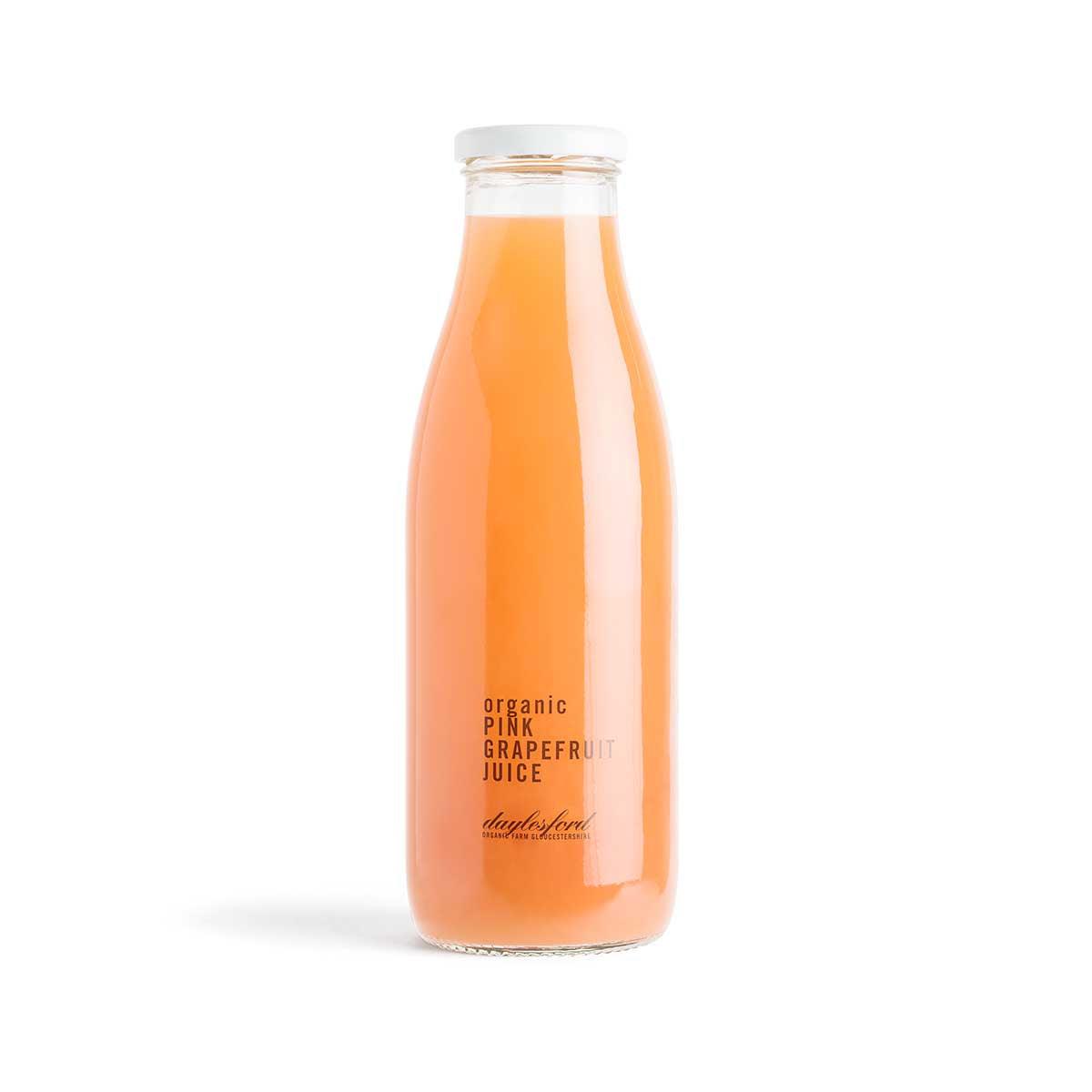 Organic pink grapefruit juice bottle, clear glass with amber-orange liquid and label