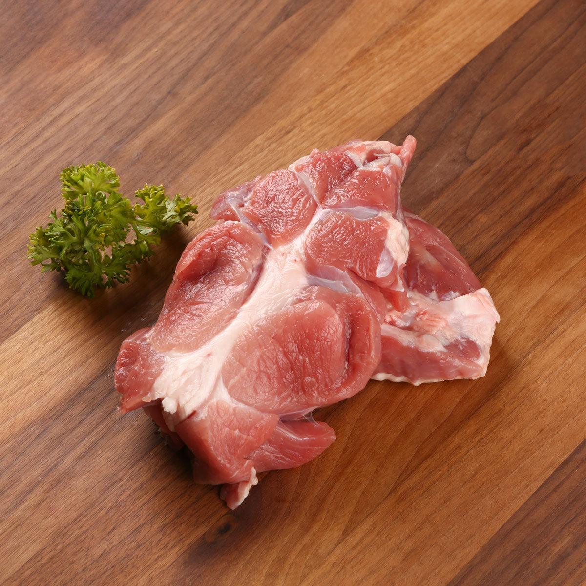 Chilled organic pork shin, raw meat pieces with visible white fat and marbling