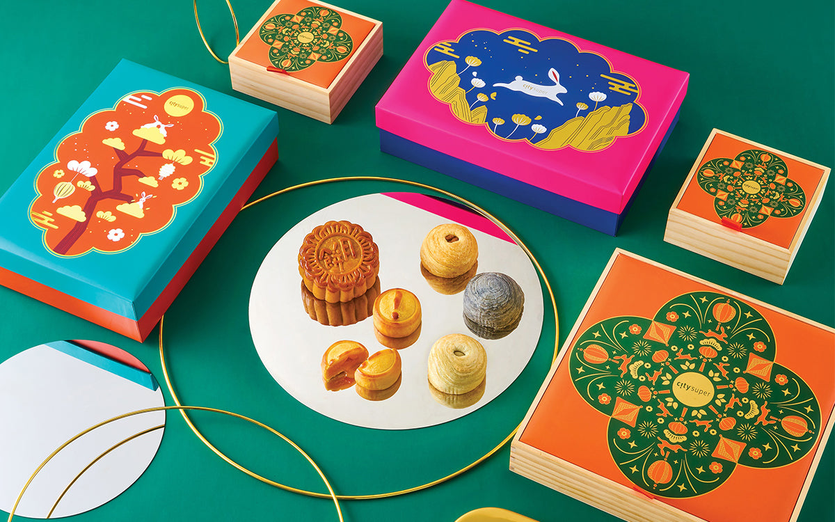 Mooncake gift set with colorful boxes and assorted mooncakes on a white tray