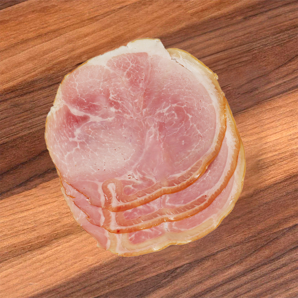 Naturally smoked grandfather ham slices, pink interior with golden fat edges