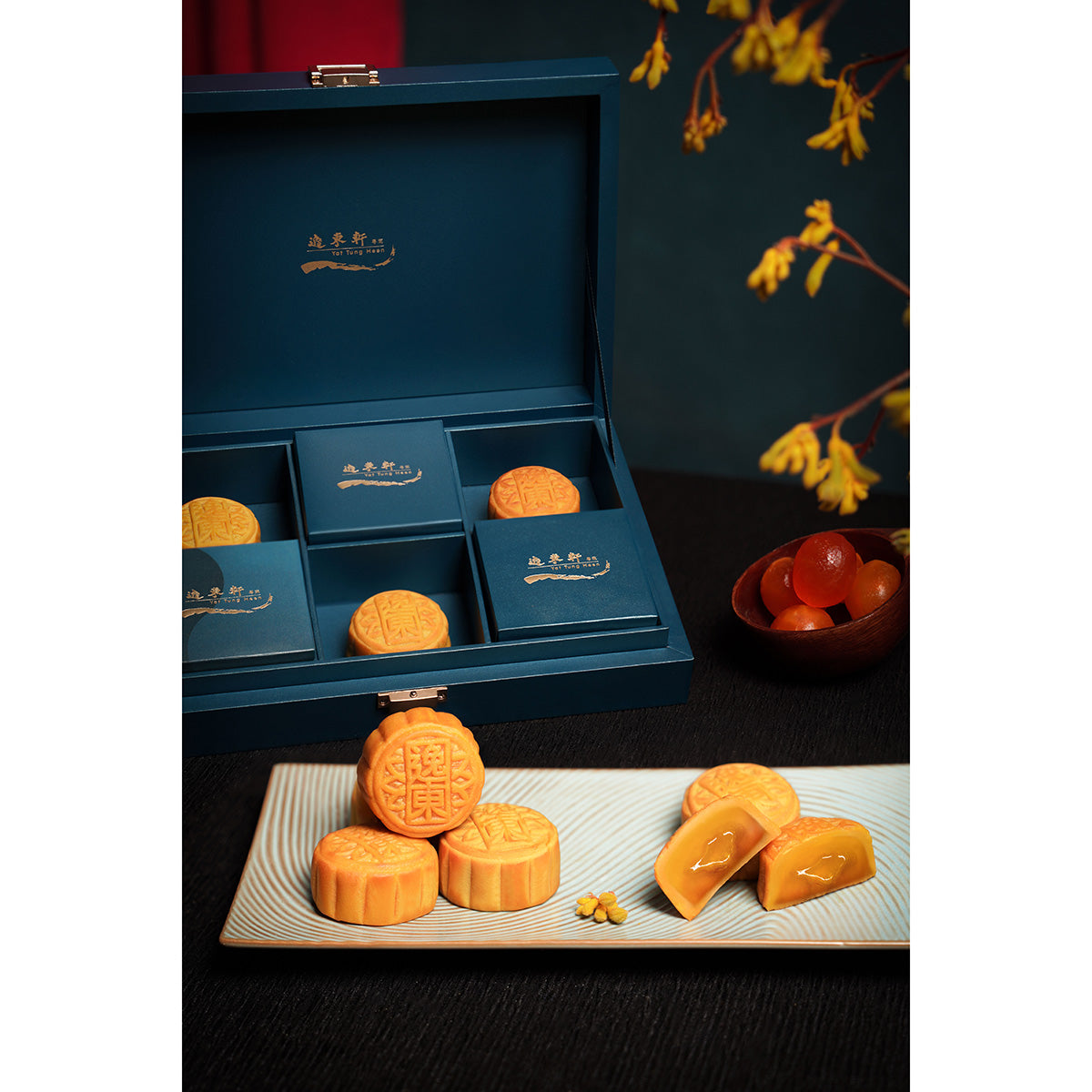 Mini lava egg custard mooncakes in an open blue gift box with round and sliced pieces