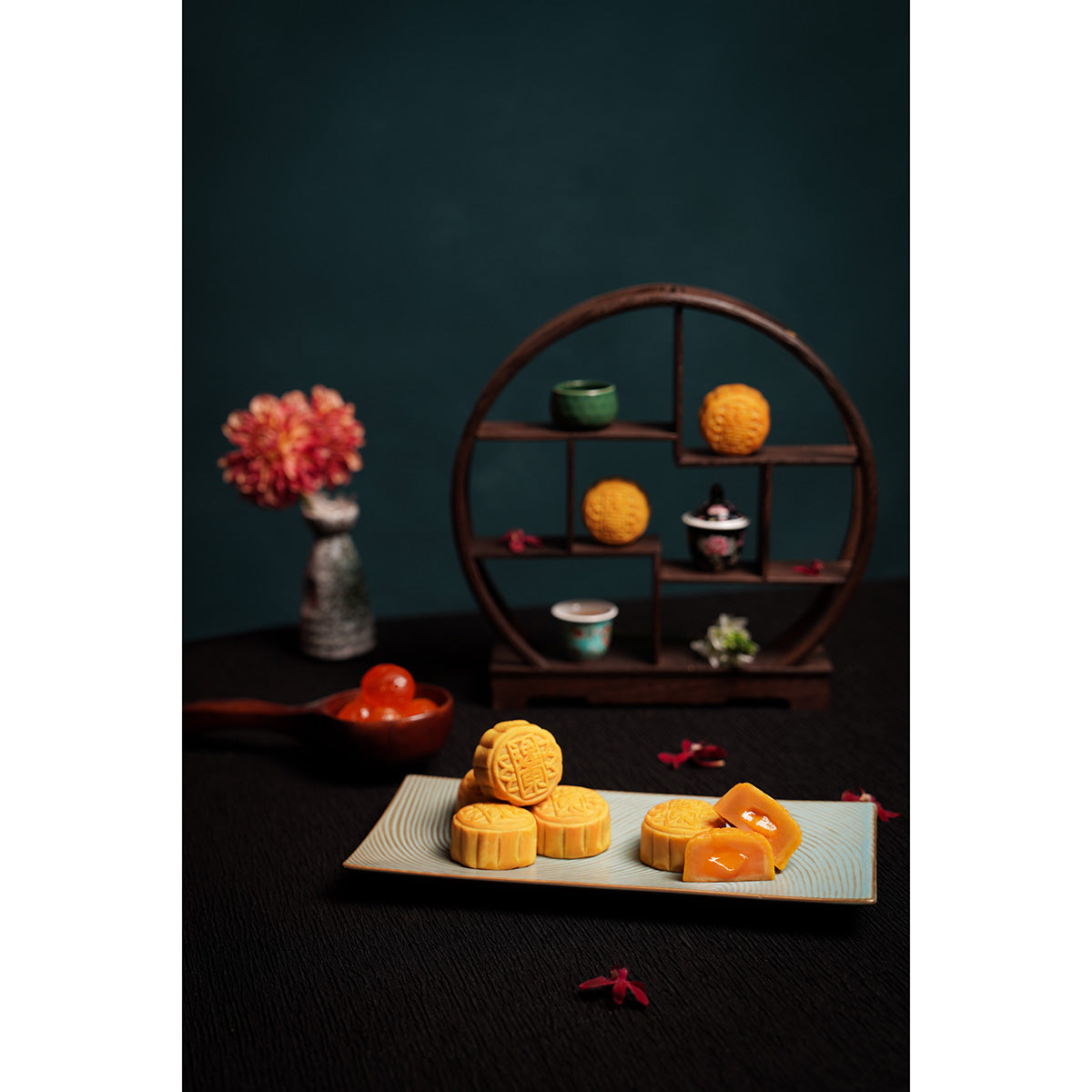 Mini lava egg custard mooncakes in a gold tray, several round pastries with embossed tops