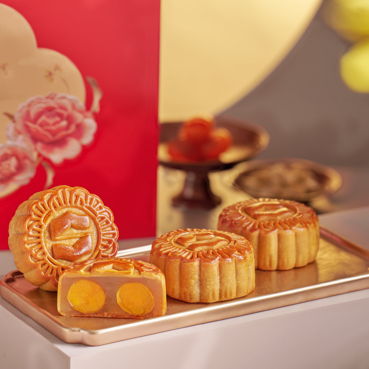 Mooncakes with double egg yolk filling on a serving tray, sliced pieces visible