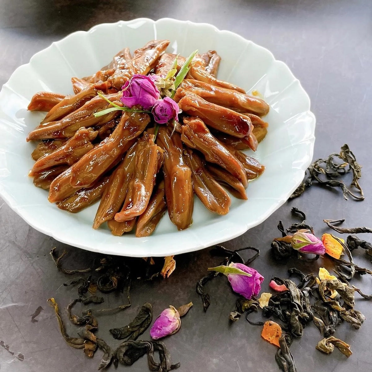 BLUEDROP braised duck tongues in soy sauce in a white serving bowl