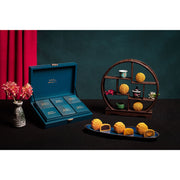 Assorted mini mooncakes on a tray with a wooden display and gift box