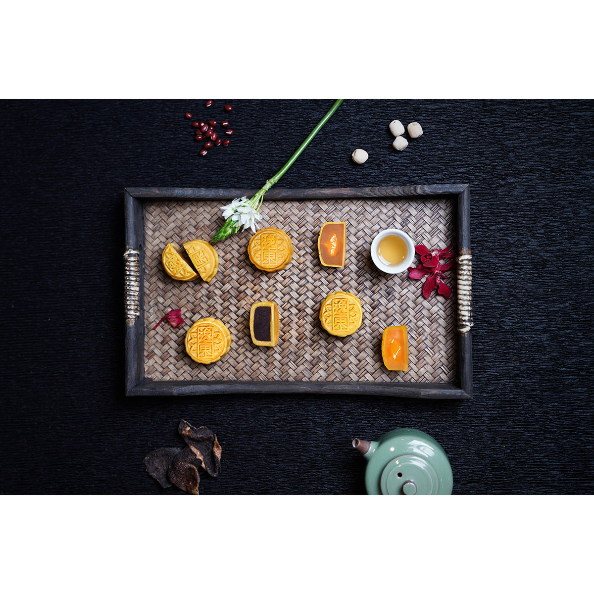 Mini mooncake assortment with several cut pieces on a metal tray