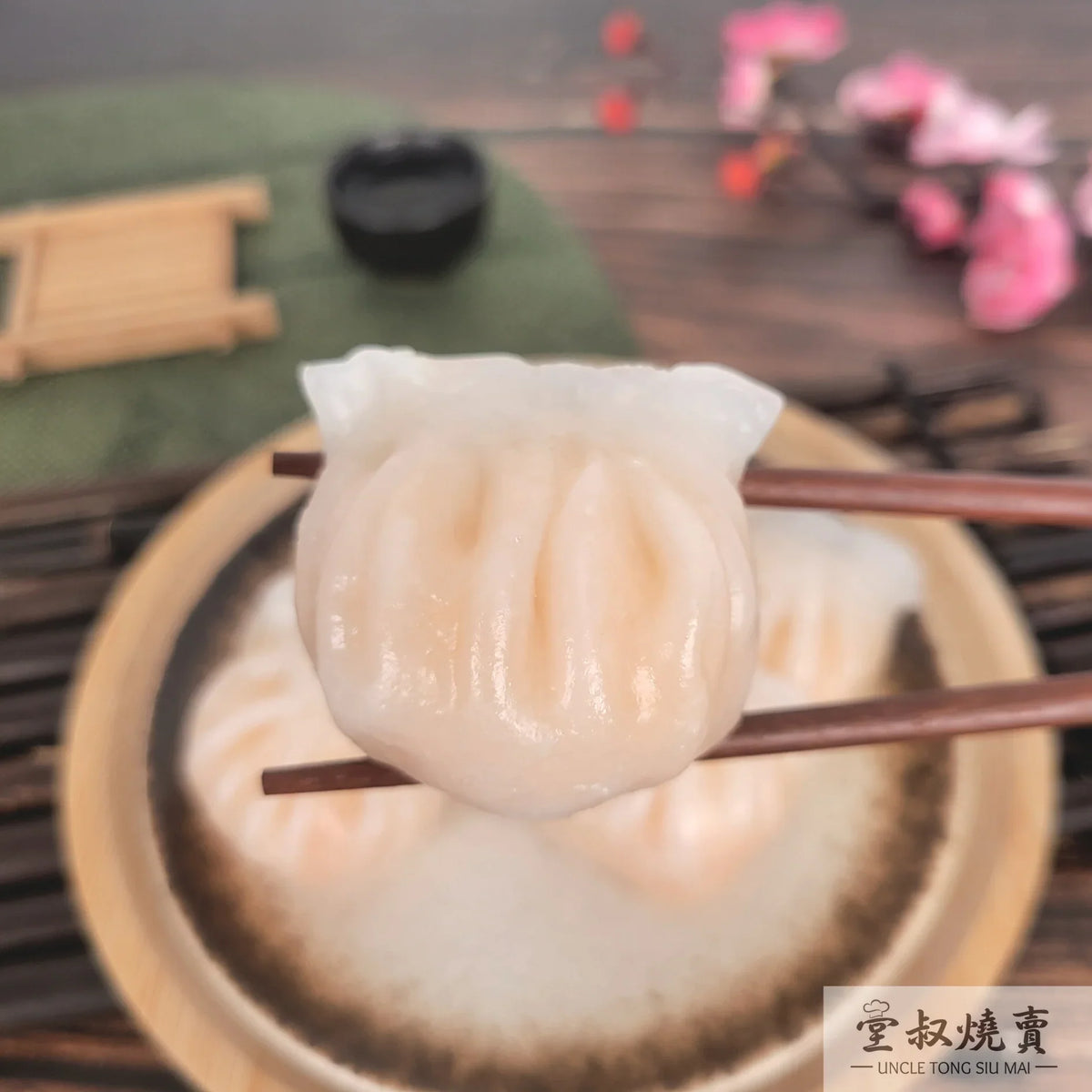 Steamed shrimp siu mai dumpling on chopsticks, pale translucent skin