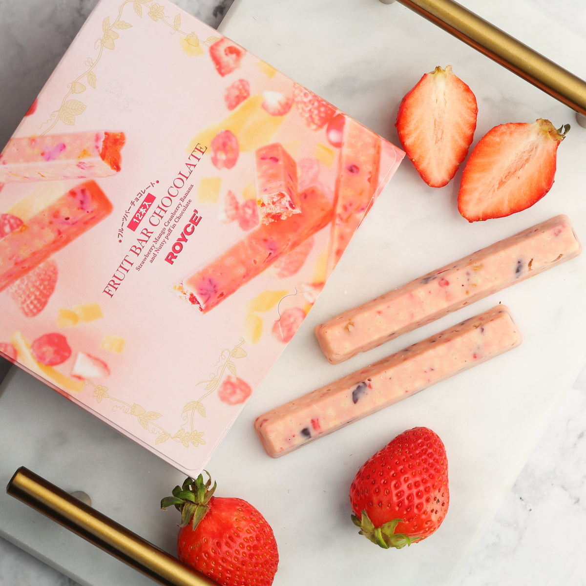 ROYCE' fruit bar chocolate pack with two bar pieces and fresh strawberries.