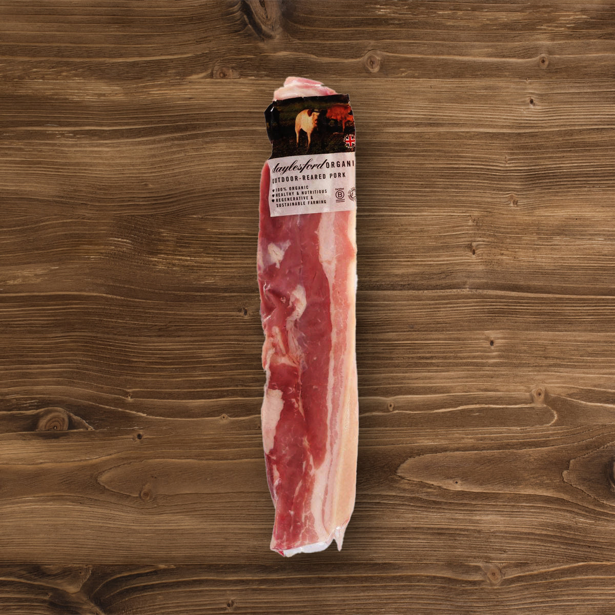 Bone-in skin-on pork belly, vacuum-sealed pack with label; raw pink meat and pale fat