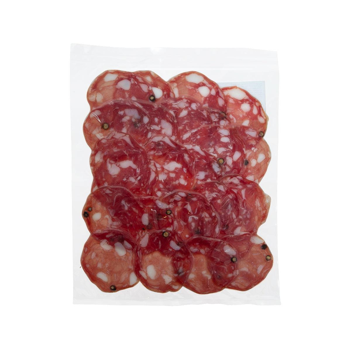 Red salami slices stacked in a clear plastic wrapper