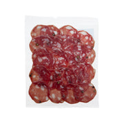 Red salami slices stacked in a clear plastic wrapper
