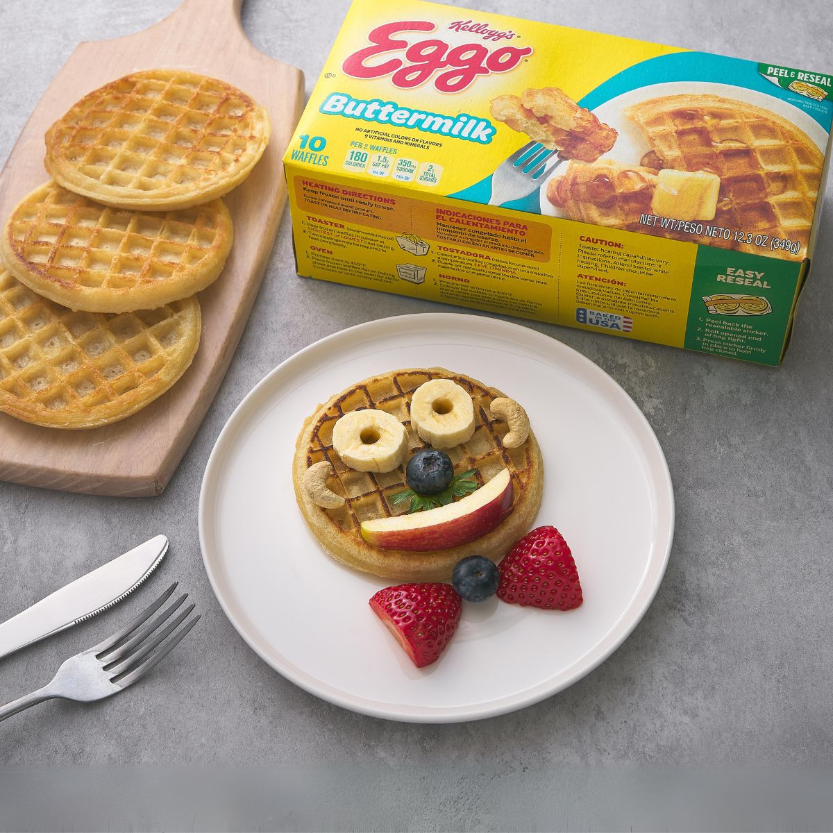 Eggo buttermilk waffles with plated waffle halves, apple slices, strawberries and blueberries