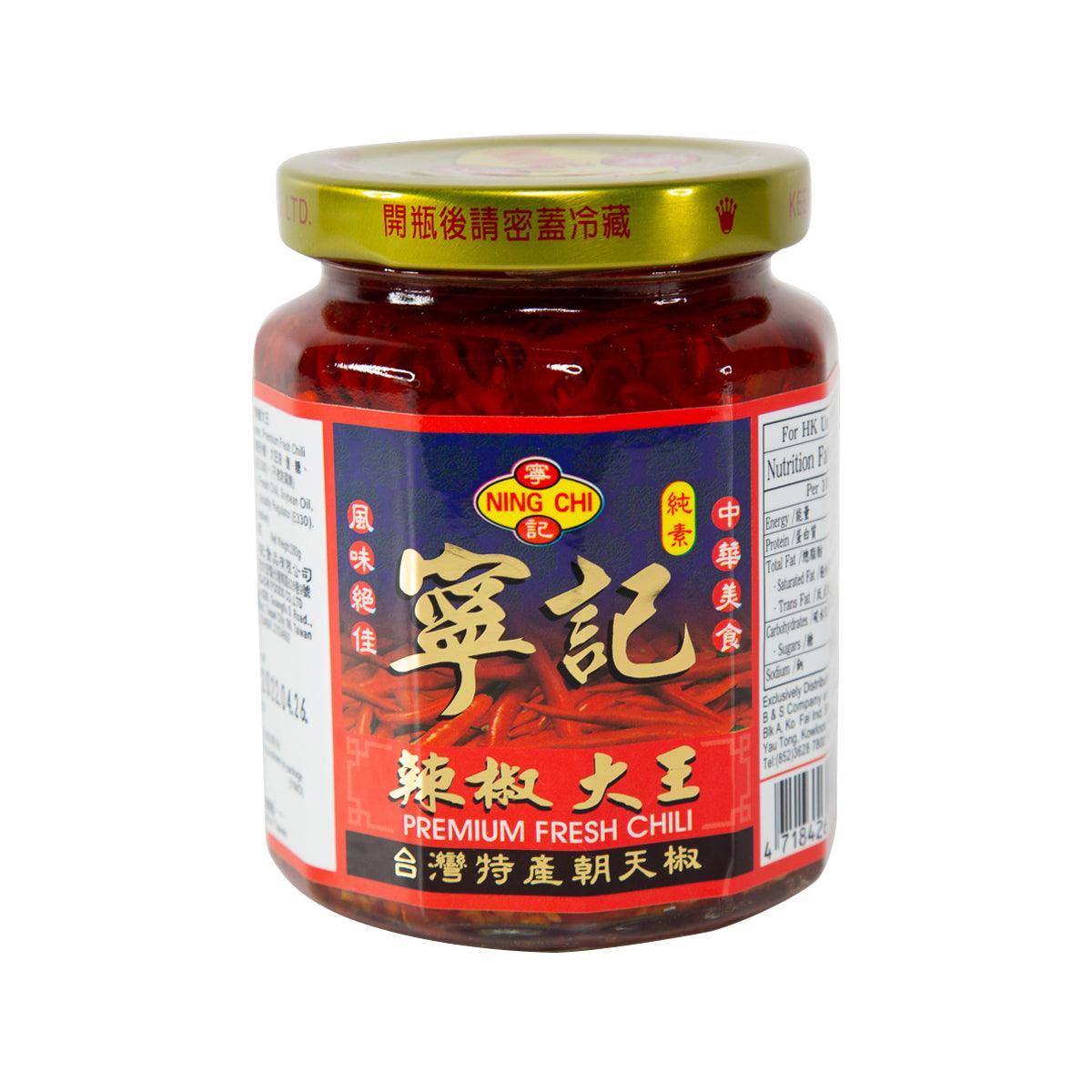Glass jar of red chili sauce with gold screw-top lid