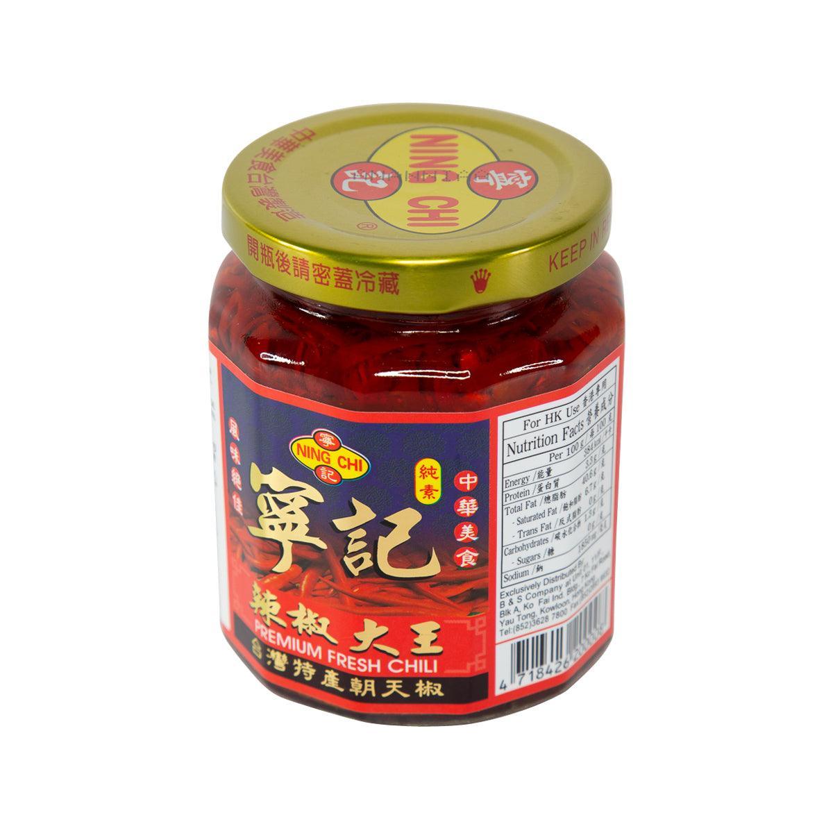 Red chili sauce jar with gold lid and blue front label