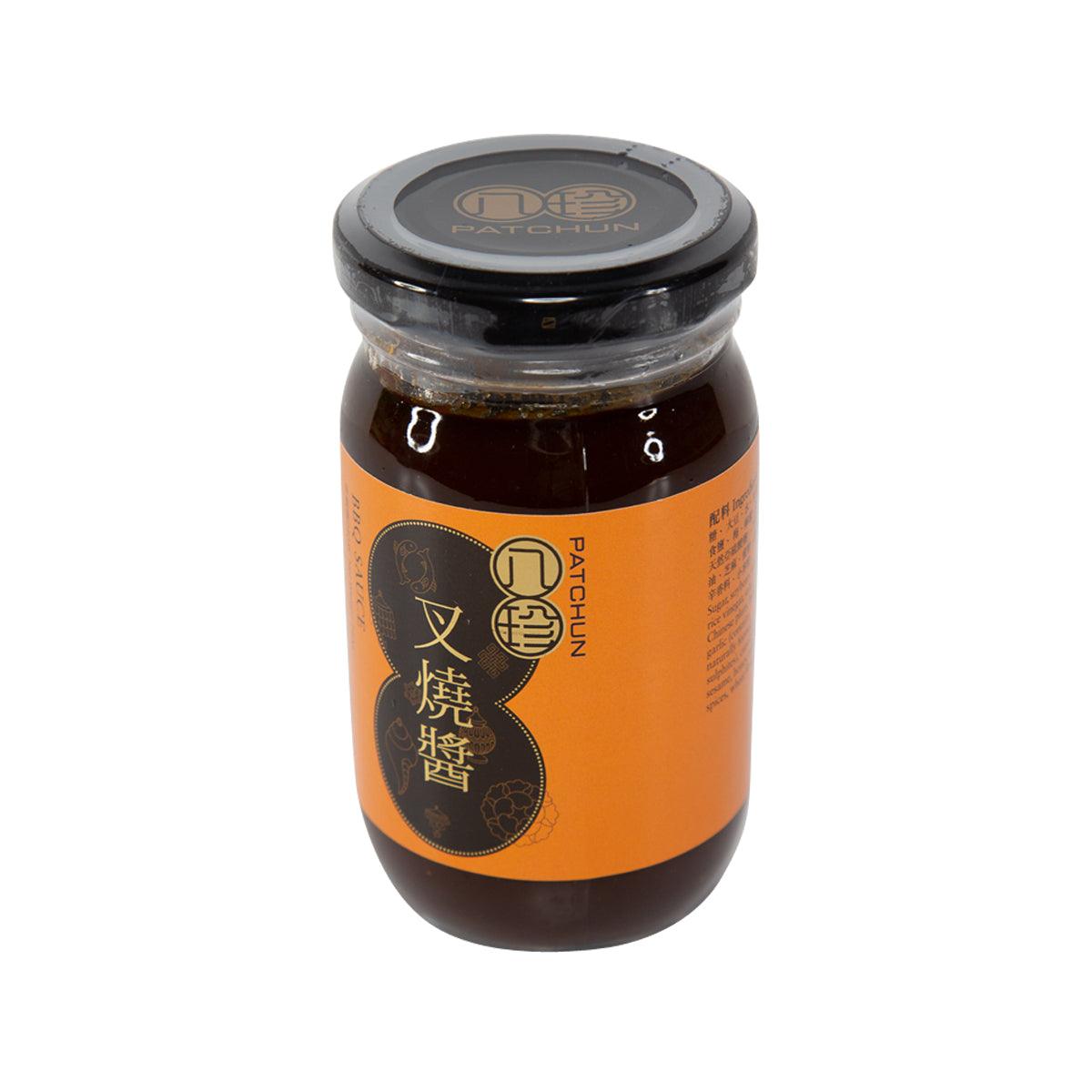 BBQ sauce jar with orange label and dark brown sauce visible under black lid