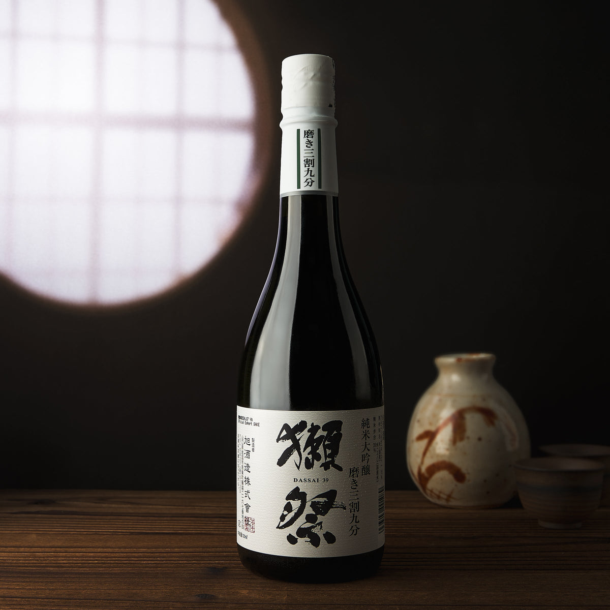DASSAI 39 Junmai Daiginjo bottle with white cap and dark label, front view on table.