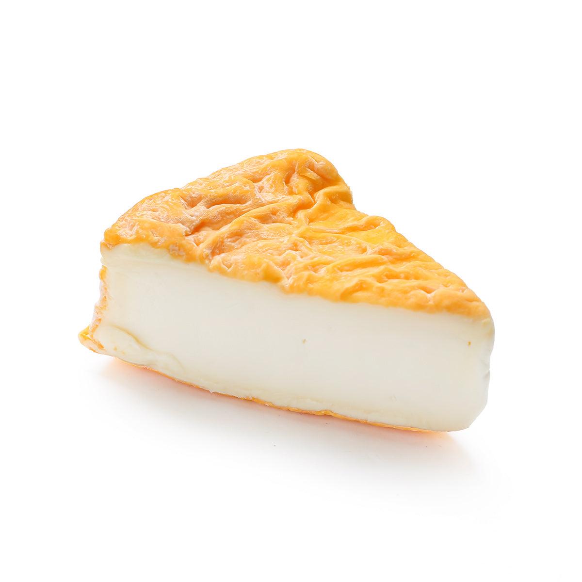 GERMAIN Langres wash-rind cheese wedge, pale yellow interior with orange rind.
