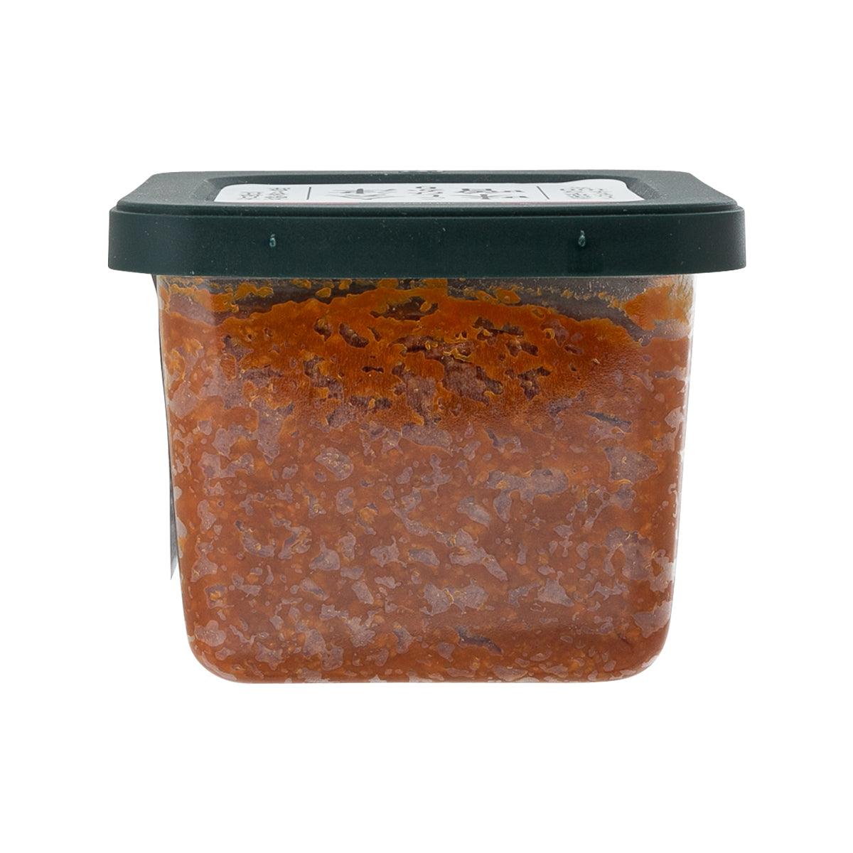 Rice miso paste jar with dark lid and brown-orange paste visible