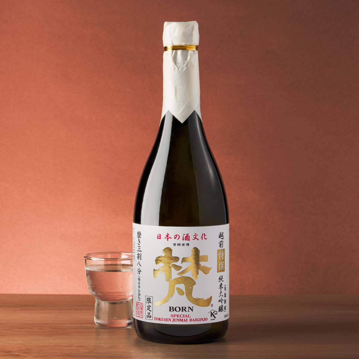 BORN sake bottle with cream cap, gold label, and small glass of sake