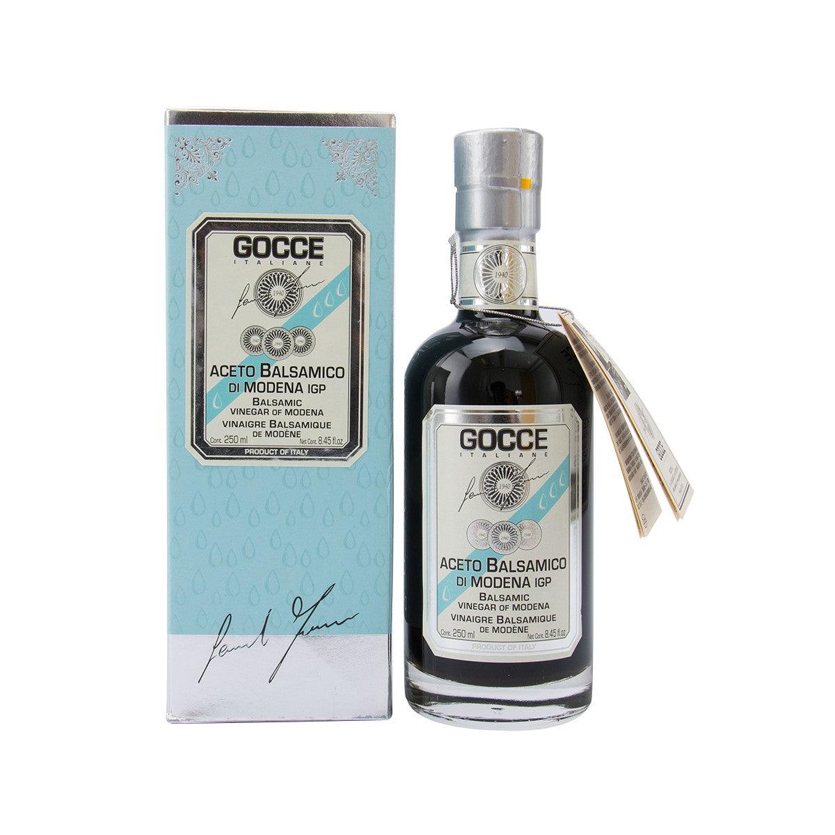 Balsamic vinegar bottle with pour spout and GOCCE label, shown with matching carton