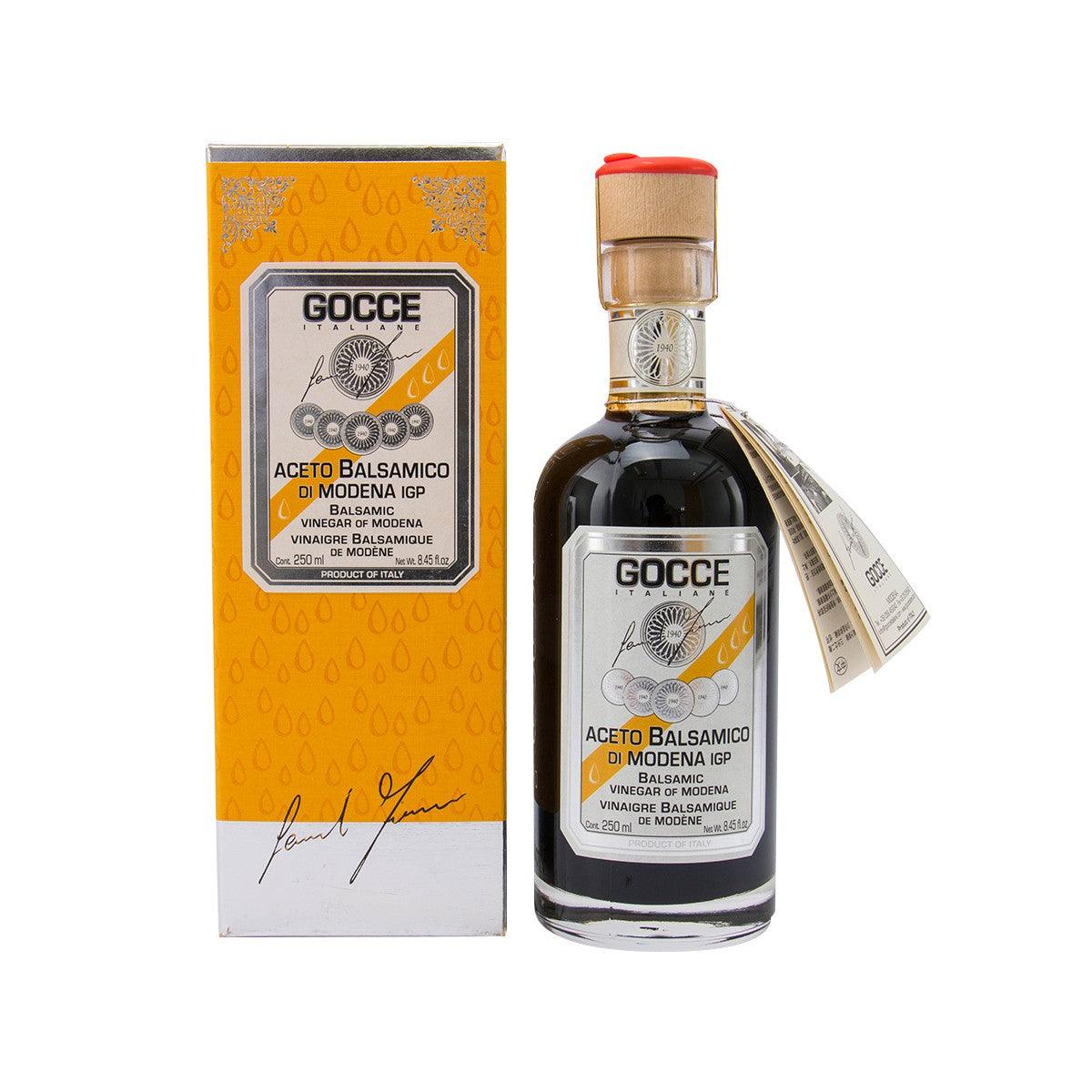 Balsamic vinegar bottle with paper carton, dark amber glass and red cap