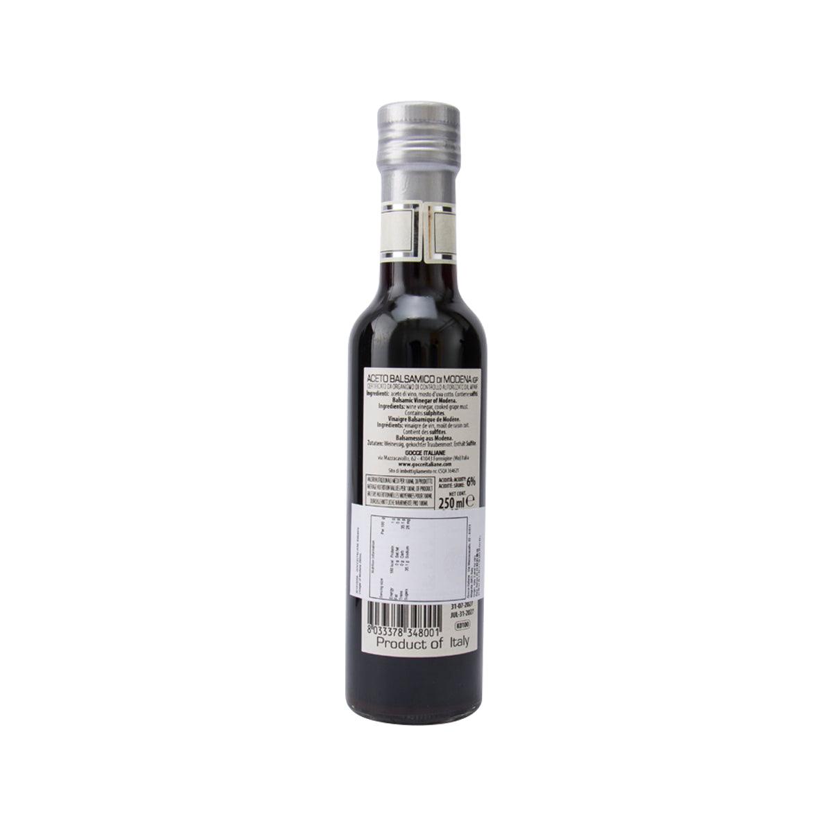Balsamic vinegar bottle with silver cap and GOCCE back label on dark glass