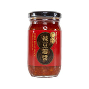 Red chili bean sauce in glass jar with black screw lid