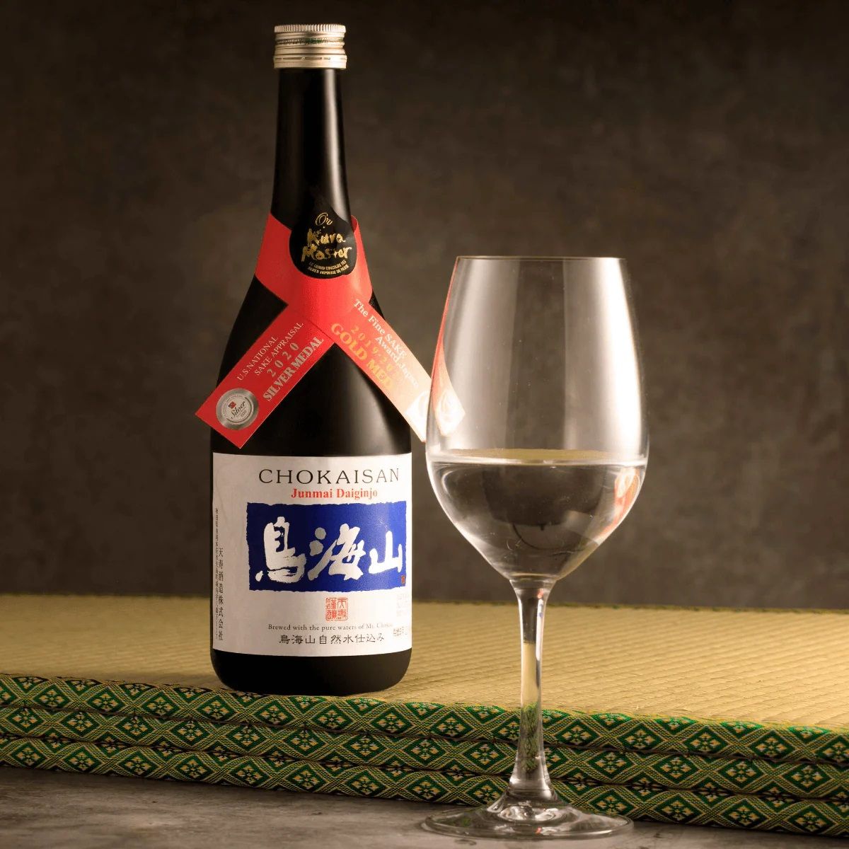 TENJU Chokaisan junmai daiginjo sake bottle with wine glass, dark label, gold foil