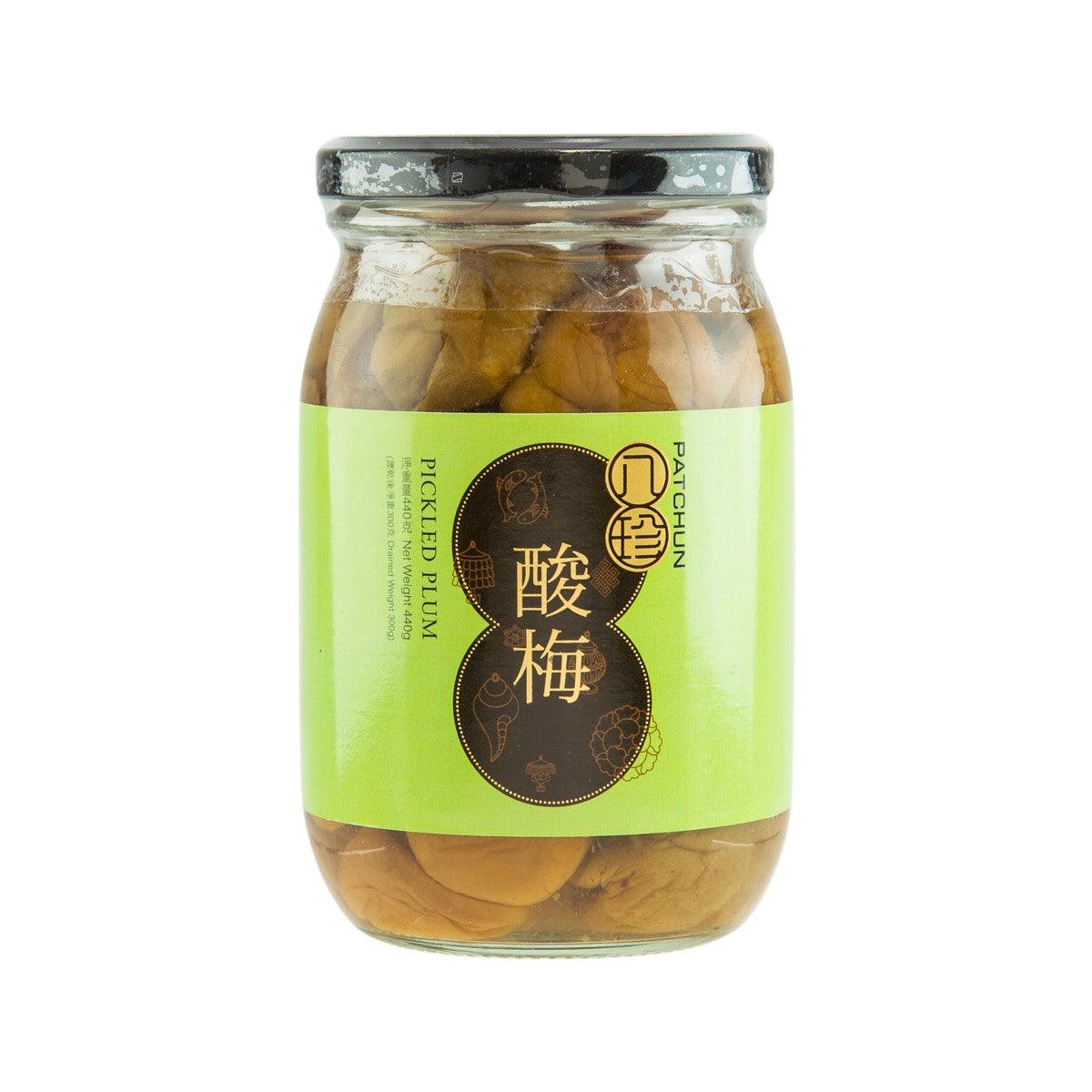 Pickled plum jar with clear glass and dark lid, whole plums in brine