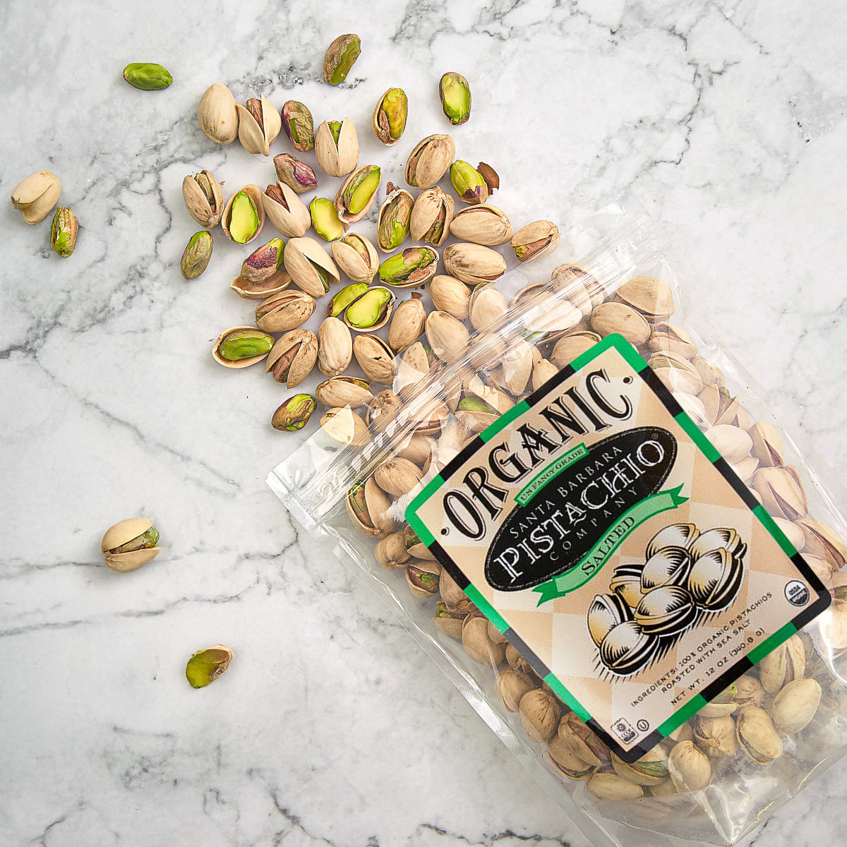 Organic salted pistachios bag with green label and scattered pistachio nuts