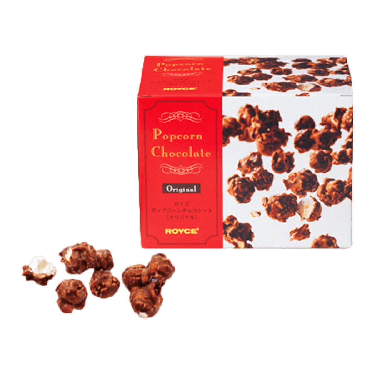 Chocolate popcorn candy gift box with red ROYCE' label and scattered coated pieces