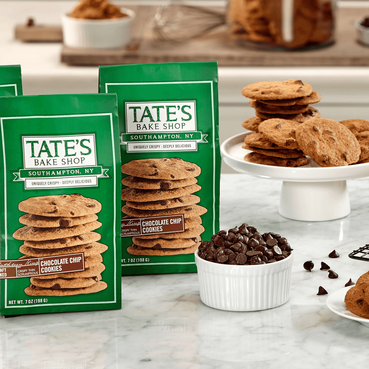 Chocolate chip cookies with TATE'S Bake Shop packages and scattered chocolate chunks