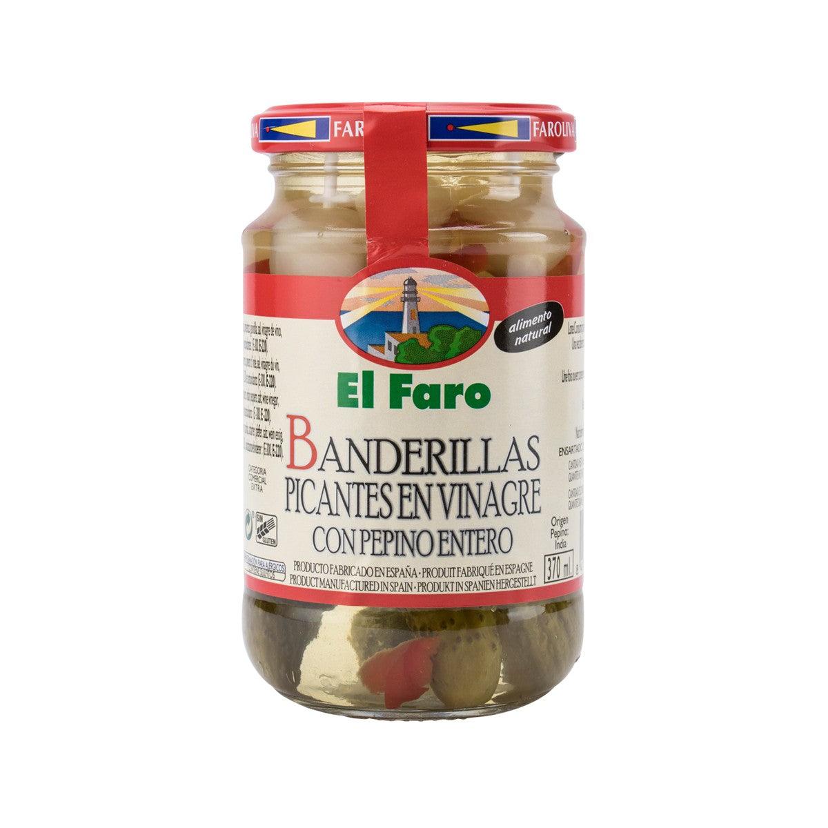 Jar of pickled hot banderillas and whole gherkin cucumbers in glass with brine