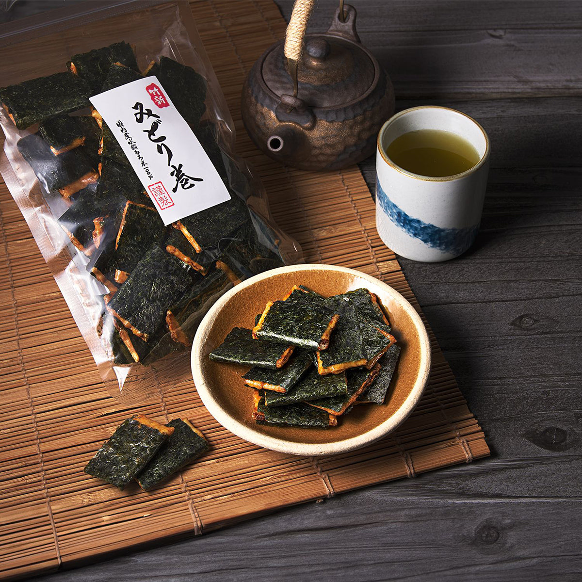 Seaweed rolled rice crackers: nori snack squares in bowl beside sealed bag