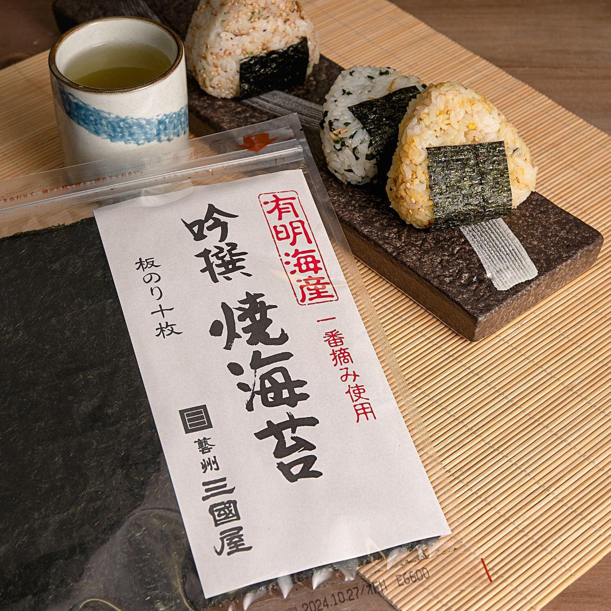 Roasted nori seaweed sheets pack with rice-and-nori roll pieces on tray.