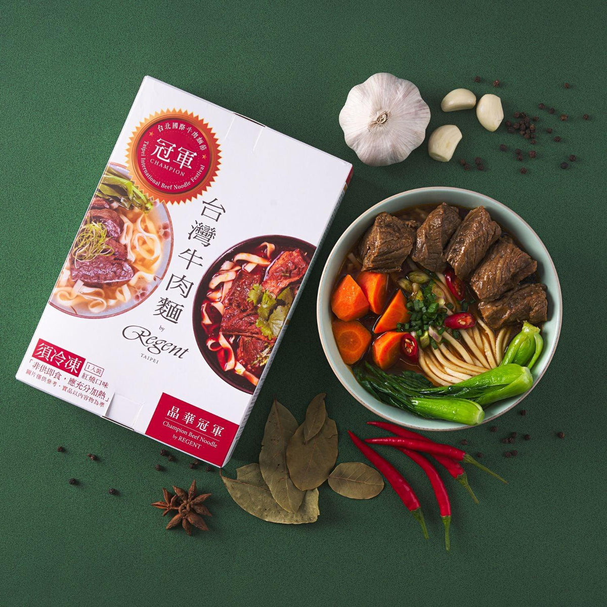 Beef noodle bowl with braised beef and vegetables next to Regent Champion box