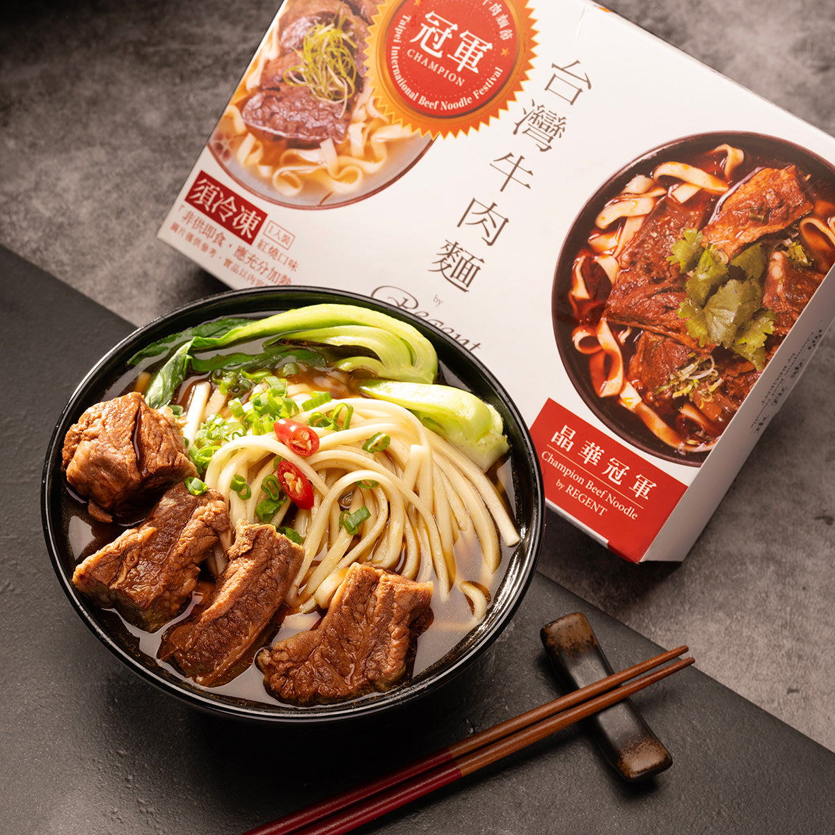 Beef noodle bowl with braised beef and noodles next to Regent Champion package