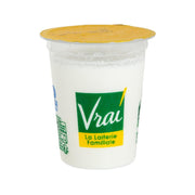 Goat milk yogurt cup with golden lid and green Vrai label on white container