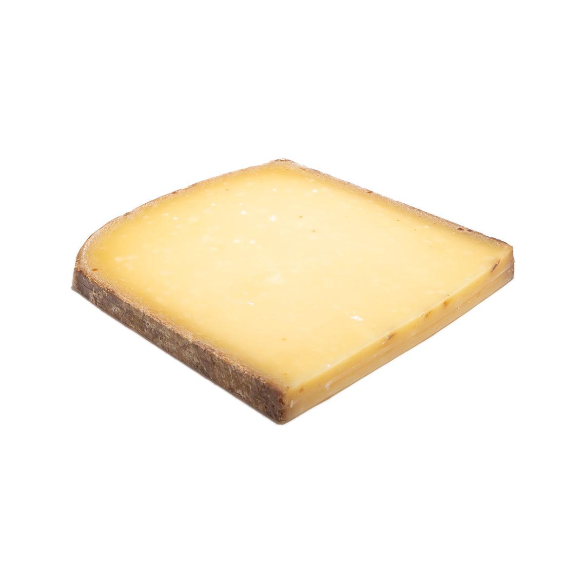 Aged cheese wedge with pale yellow interior and dark brown rind edge