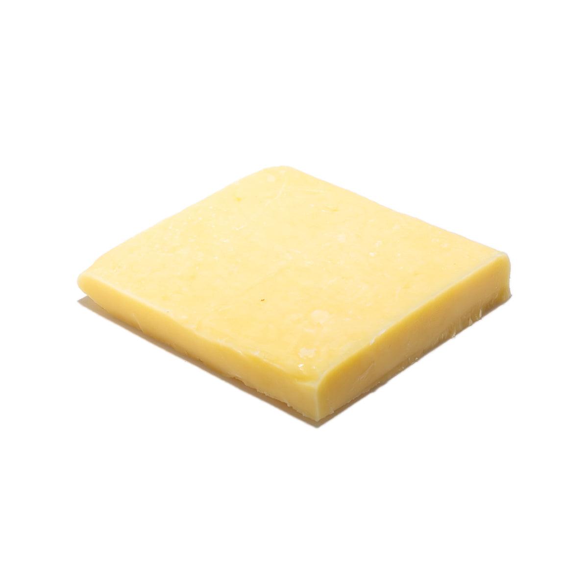 Mild cheddar cheese wedge, pale yellow square with smooth surface
