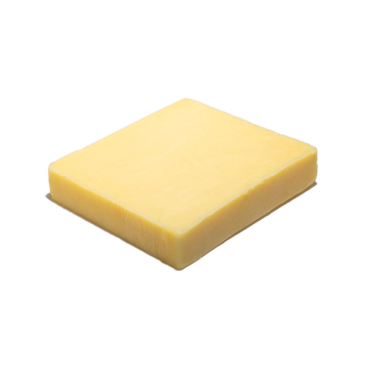 Mature cheddar cheese block, pale yellow, rectangular cut