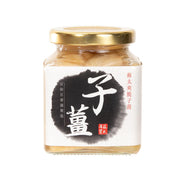 Pickled ginger slices in glass jar with gold lid, beige ginger pieces visible.