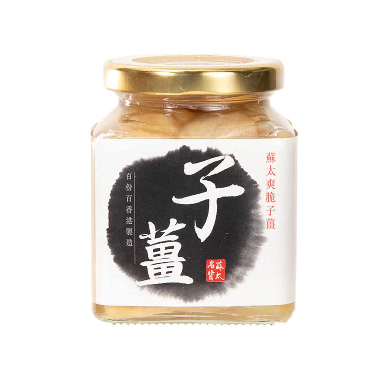 Pickled ginger slices in glass jar with gold lid, beige ginger pieces visible.