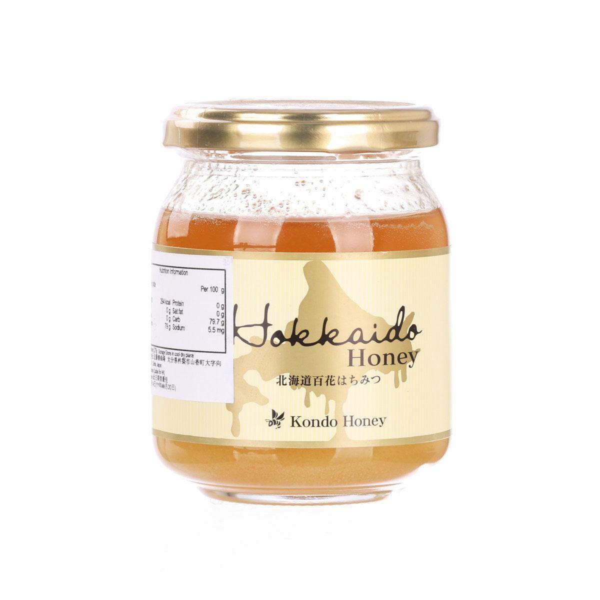 Honey jar with gold lid, amber honey, and front label