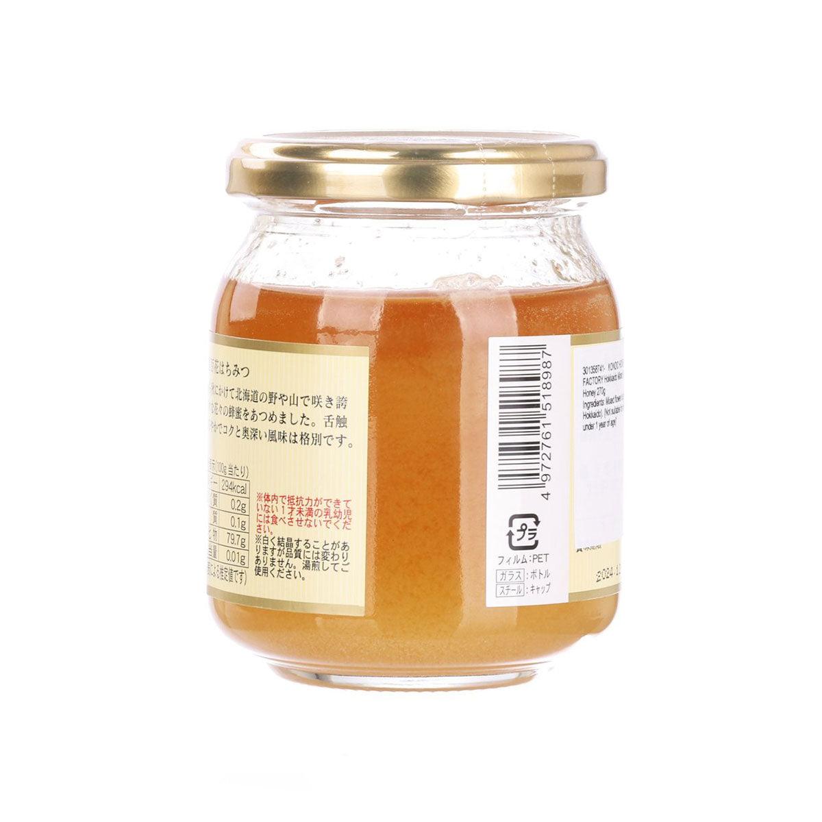 Honey jar with gold lid, amber honey, and barcode back label