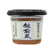 Miso paste in clear plastic tub with black lid, green-and-white front label.