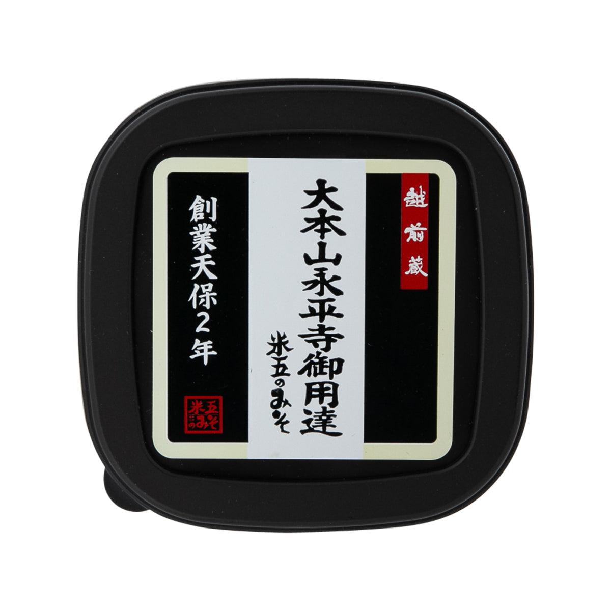 Miso paste container lid with black rim and square label, printed text and logo.