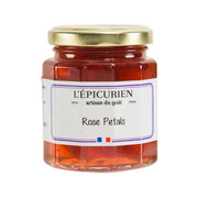 Rose petals spread in glass jar with gold lid, red jam label