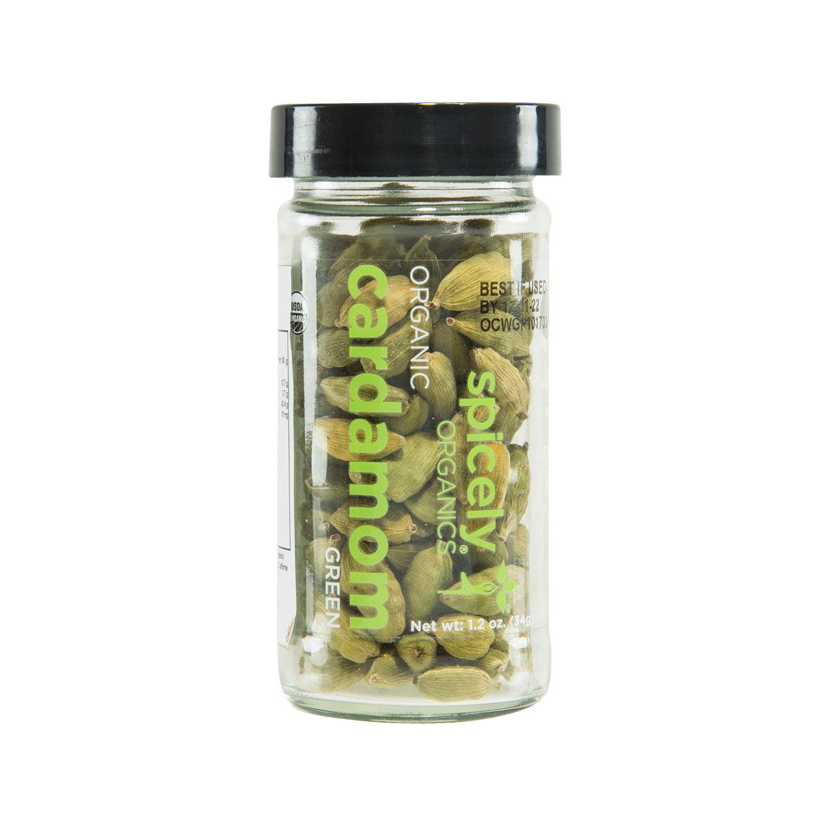 Organic green cardamom pods in glass jar with black lid, labeled SPICELY